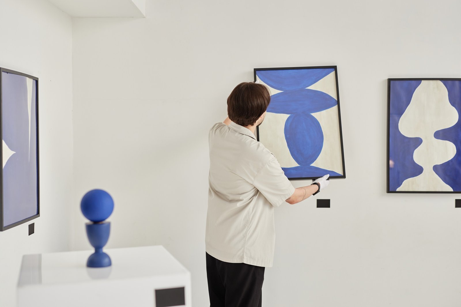 Back View of Man Hanging Art Painting Preparing for Exhibition in Museum